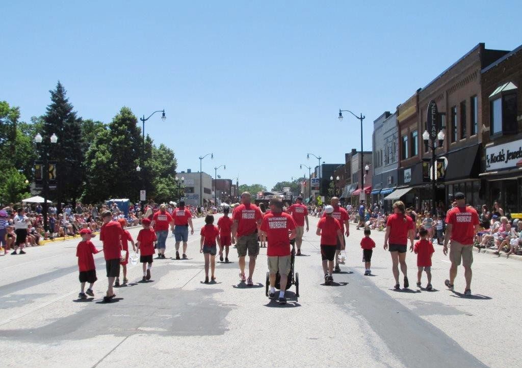 Hutchinson Fire Department walkers behind float in parade
